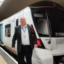 Driver Mark Webb in front of one of the first trains to run in passenger service digital in-cab signalling on the platform in front of the train