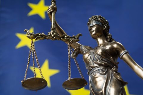 Lady Justice in front of an EU flag