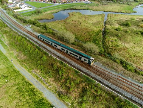 Yellow and green traditional Irish rail color train on the way from Galway city