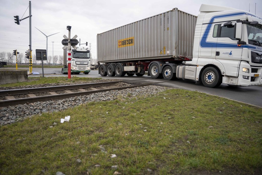 Vrachtwagens steken overweg bij container terminal in Antwerpen over