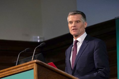 Close up of UK Transport Secretary Mark Harper in smart suit and tie delivering speech at lectern